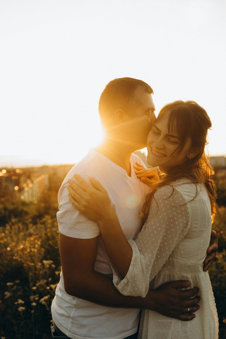 Pareja en un abrazo cariñoso en un campo soleado